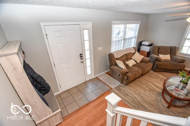 tiled foyer entrance featuring ceiling fan and a textured ceiling