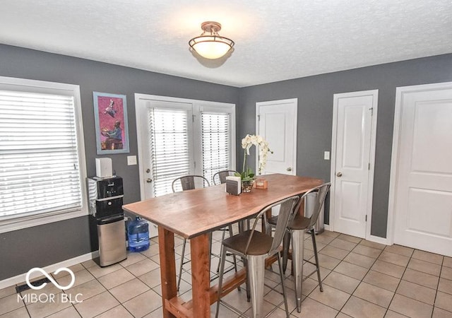 dining room with light tile patterned floors and a textured ceiling