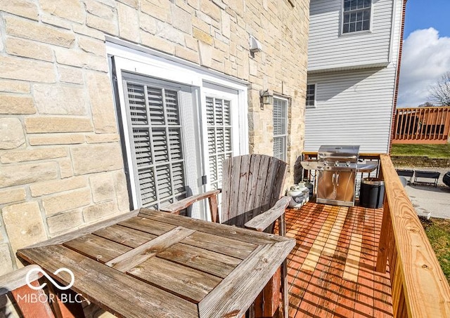 wooden deck featuring a grill