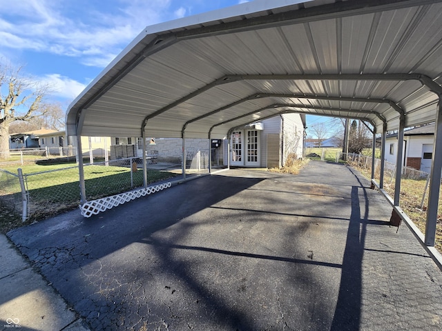 view of vehicle parking with a lawn and a carport