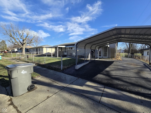 view of parking / parking lot featuring a yard and a carport