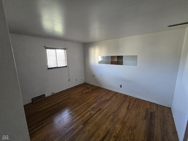 unfurnished room with dark hardwood / wood-style floors