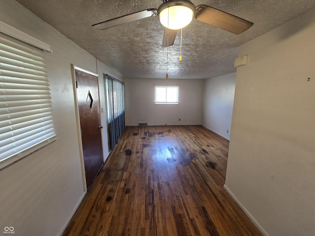 spare room with a textured ceiling, dark hardwood / wood-style flooring, and ceiling fan