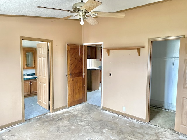 unfurnished bedroom with ensuite bath, a textured ceiling, a closet, lofted ceiling, and ceiling fan