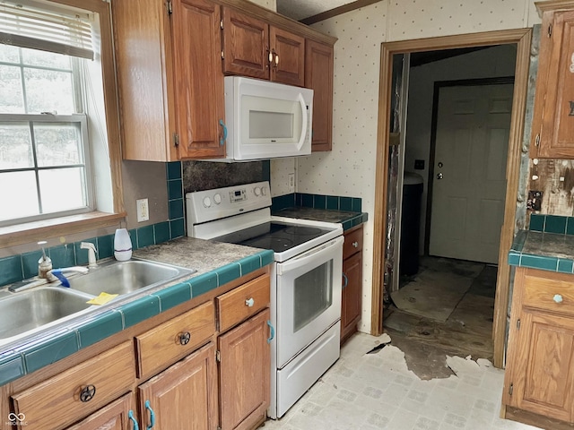 kitchen featuring white appliances, a wealth of natural light, sink, and tile counters