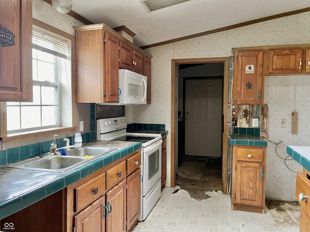 kitchen featuring white appliances, a textured ceiling, tile countertops, and vaulted ceiling