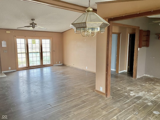 unfurnished room featuring ceiling fan with notable chandelier, hardwood / wood-style flooring, a textured ceiling, and ornamental molding