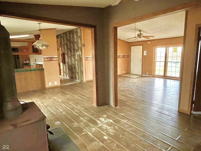 4726 E 210 N, Lebanon, IN 46052 - unfurnished living room featuring ceiling fan, wood finished floors, and a wood stove
