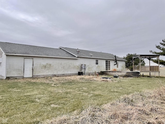 back of property with a yard and a pergola