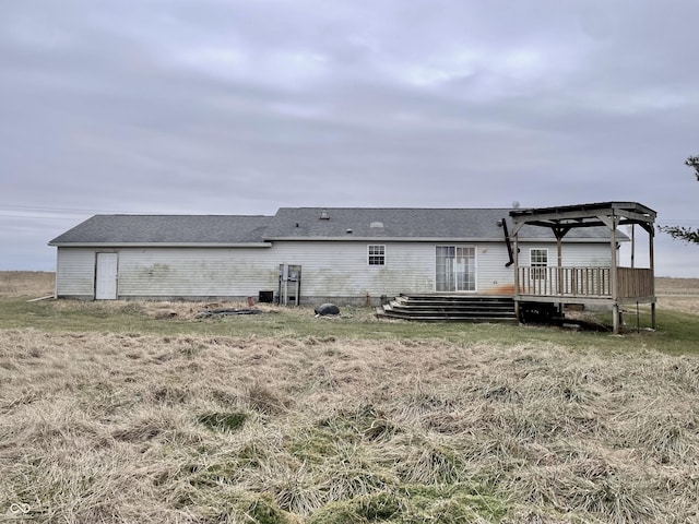 rear view of house featuring a pergola, a wooden deck, and cooling unit