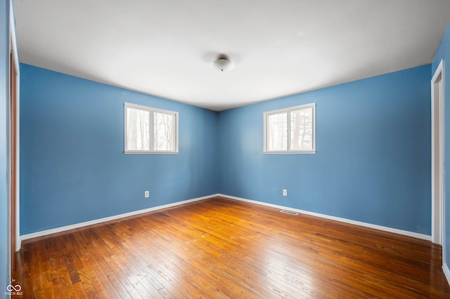 unfurnished room with a healthy amount of sunlight and wood-type flooring