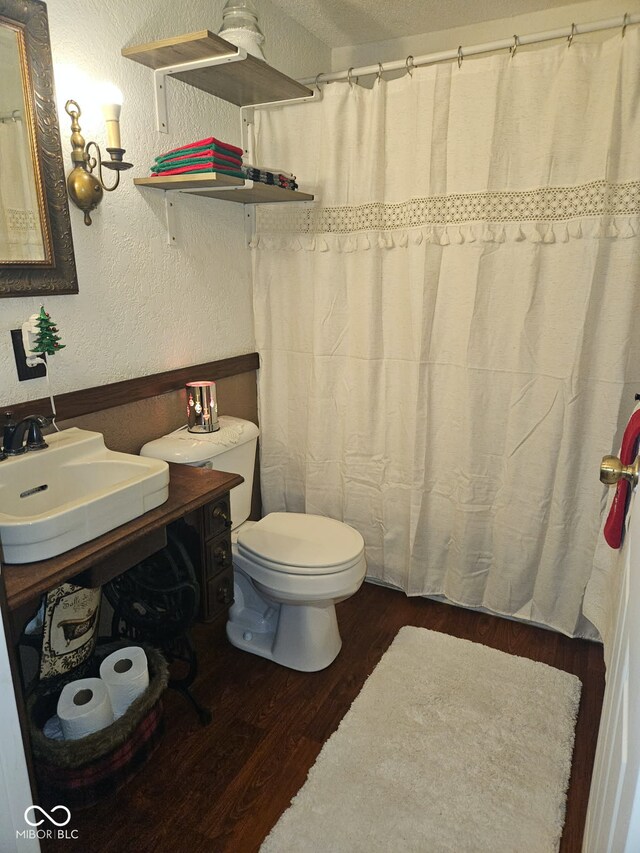 bathroom featuring hardwood / wood-style flooring, vanity, toilet, and a textured ceiling