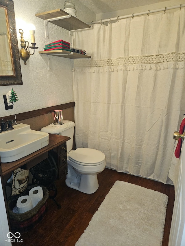 bathroom featuring vanity, a textured ceiling, hardwood / wood-style flooring, and toilet