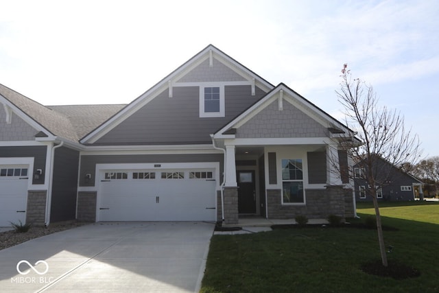 craftsman house featuring a garage and a front lawn