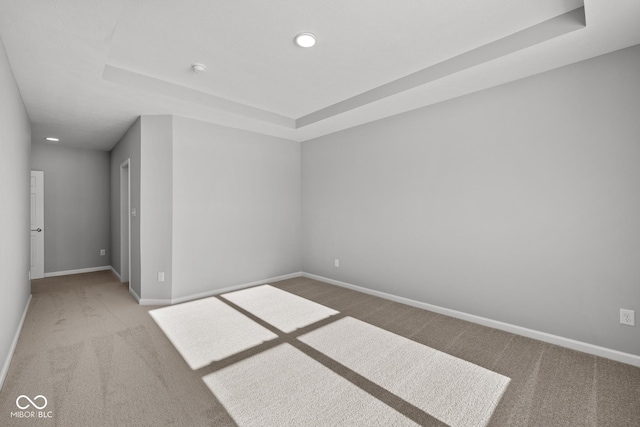 empty room with a tray ceiling and carpet floors