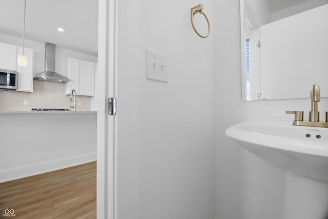 bathroom featuring wood-type flooring, sink, and tasteful backsplash