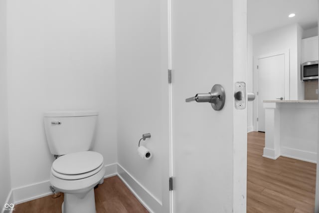 bathroom featuring hardwood / wood-style floors and toilet