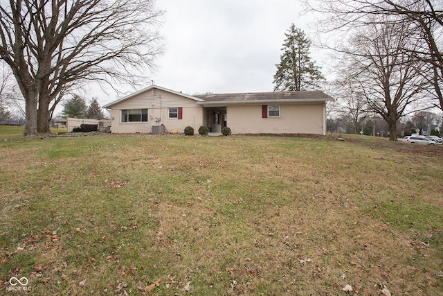 rear view of property with central AC and a yard