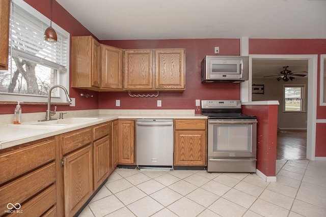 kitchen with pendant lighting, sink, ceiling fan, light tile patterned floors, and appliances with stainless steel finishes