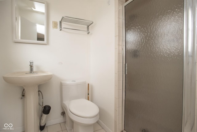 bathroom with tile patterned floors, sink, walk in shower, and toilet