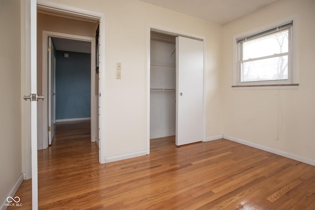 unfurnished bedroom with light wood-type flooring and a closet