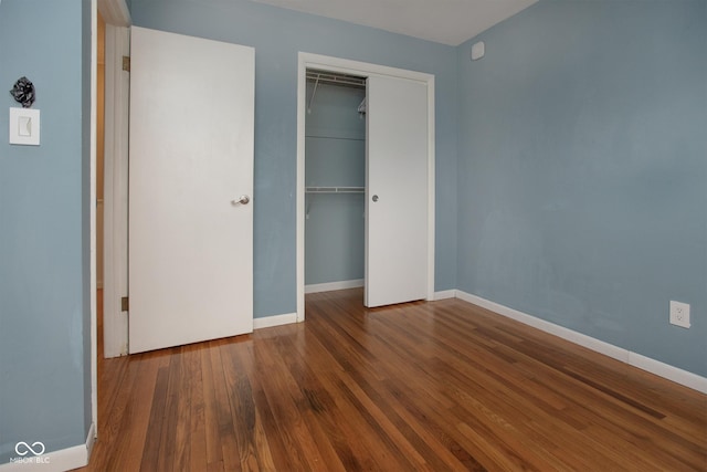 unfurnished bedroom featuring wood-type flooring and a closet