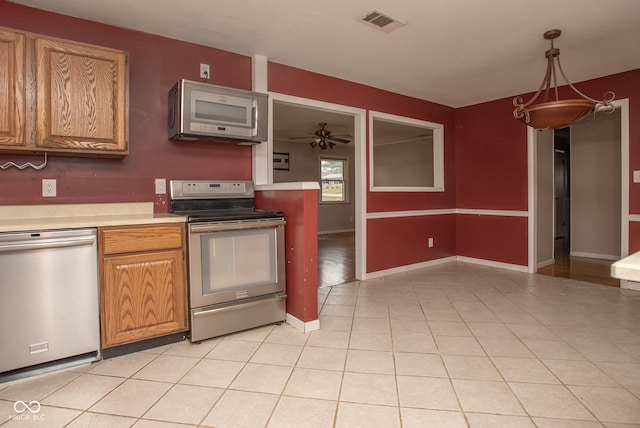 kitchen with pendant lighting, ceiling fan, light tile patterned floors, and appliances with stainless steel finishes