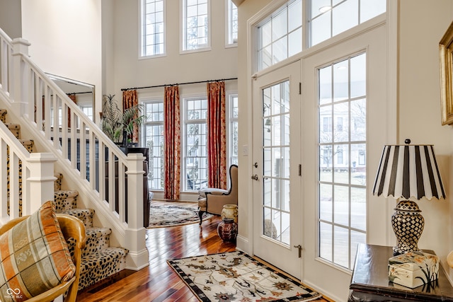 entryway featuring a towering ceiling and hardwood / wood-style floors