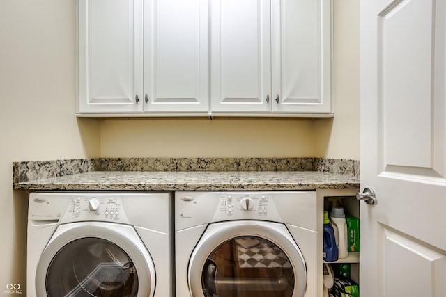 washroom with washer and dryer and cabinets