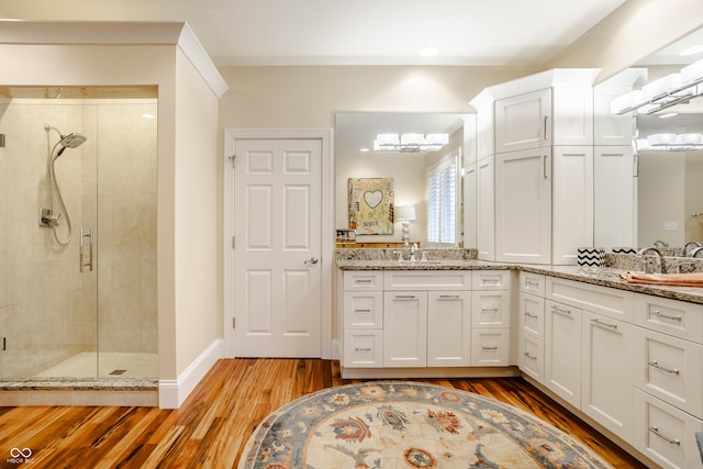 bathroom with an enclosed shower, vanity, and hardwood / wood-style flooring