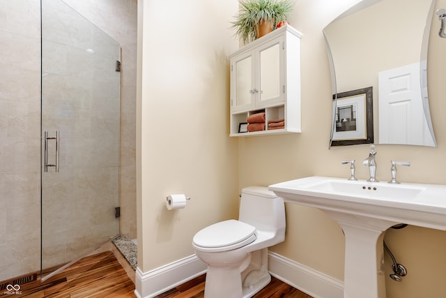 bathroom featuring toilet, hardwood / wood-style flooring, and an enclosed shower