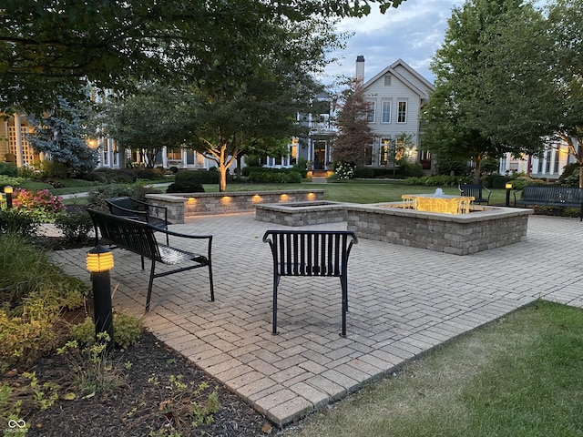 view of community featuring an outdoor fire pit and a patio