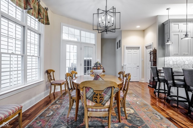 dining area featuring dark wood-type flooring, a chandelier, and a healthy amount of sunlight