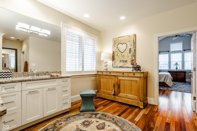 bathroom with vanity, hardwood / wood-style floors, ceiling fan, and a healthy amount of sunlight