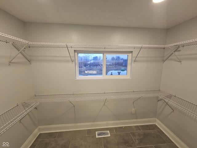 walk in closet featuring dark tile patterned floors