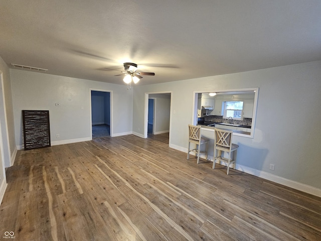 unfurnished living room featuring hardwood / wood-style flooring and ceiling fan