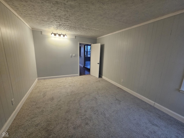 spare room featuring crown molding, carpet flooring, and a textured ceiling