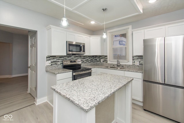 kitchen with white cabinets, a center island, stainless steel appliances, and sink