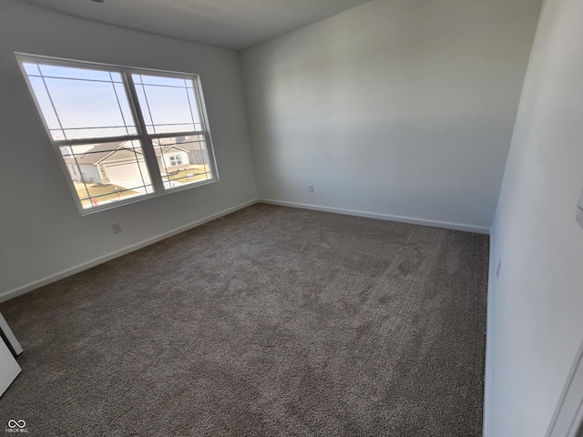 spare room featuring dark carpet