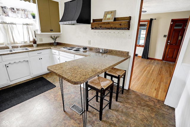 kitchen featuring white gas cooktop, exhaust hood, white cabinets, sink, and a wealth of natural light