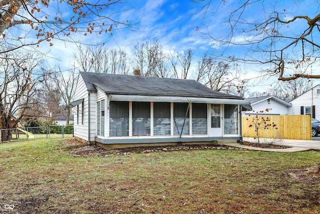 view of front facade with a sunroom and a front lawn