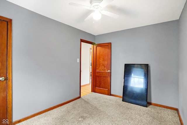 unfurnished bedroom with ceiling fan and light colored carpet