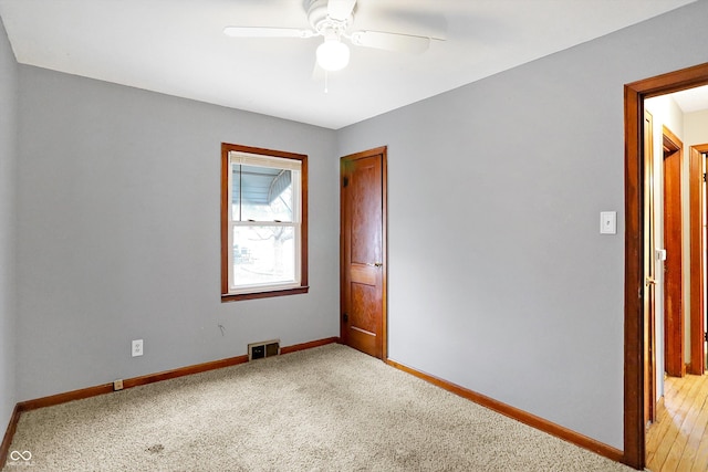 spare room with ceiling fan and carpet