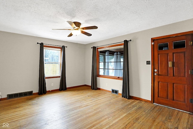 interior space with ceiling fan, light hardwood / wood-style floors, and a textured ceiling