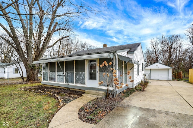 view of front facade featuring covered porch, a garage, and an outbuilding