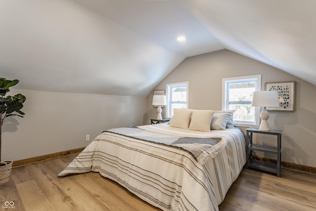 bedroom with light hardwood / wood-style flooring and lofted ceiling