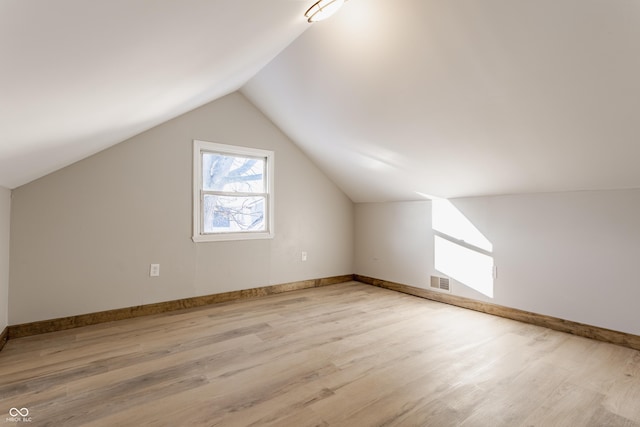 bonus room with vaulted ceiling and light hardwood / wood-style floors