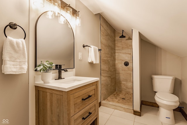 bathroom featuring toilet, vanity, a tile shower, and tile patterned flooring