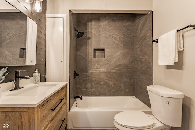 full bathroom featuring toilet, vanity, tiled shower / bath combo, and tasteful backsplash