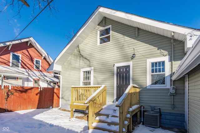 snow covered back of property with central AC unit